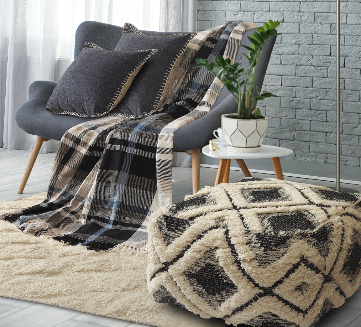 A thoughtfully styled home with woven cushions, a soft throw and textured rug